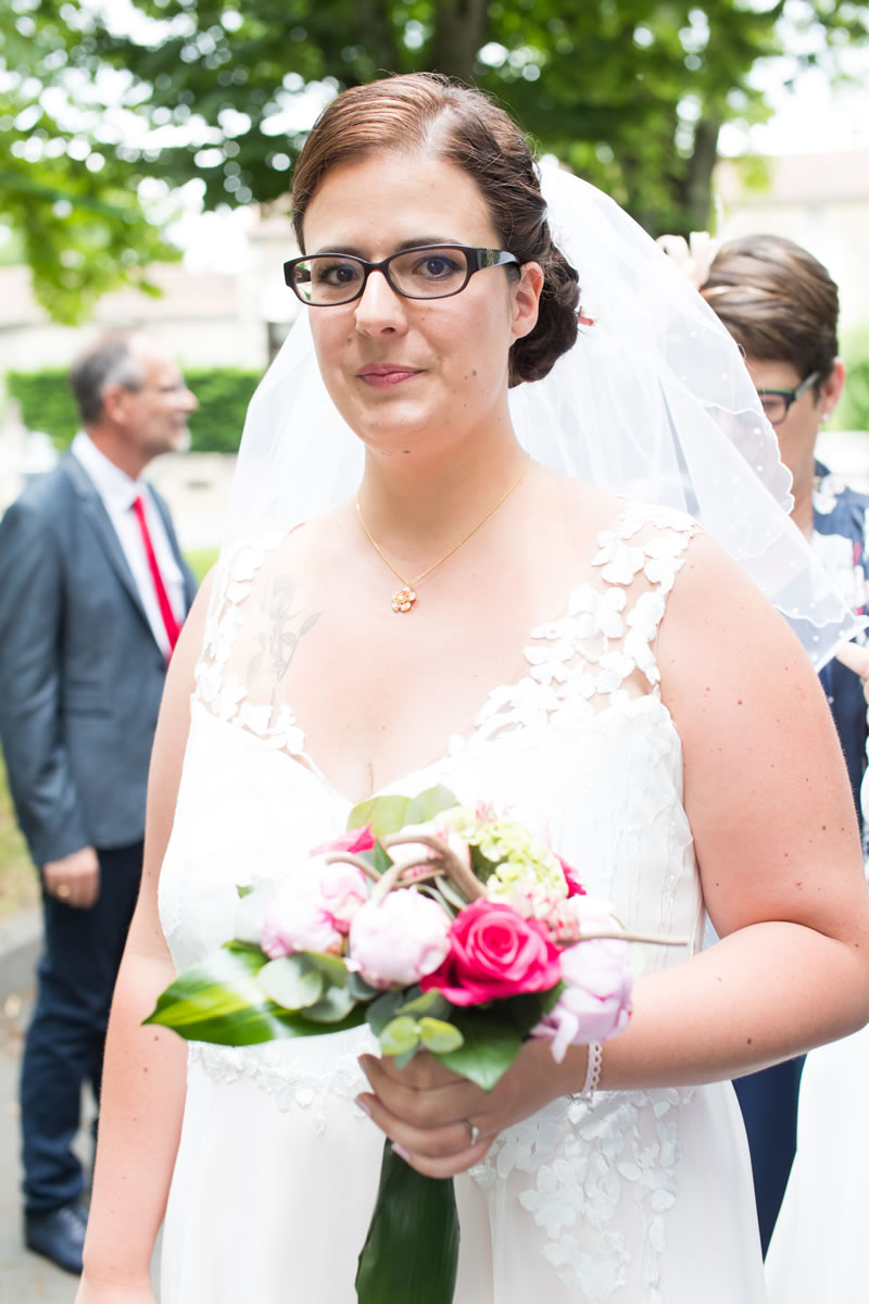 Noémie pose avec sont bouquet et sa robe sur mesure