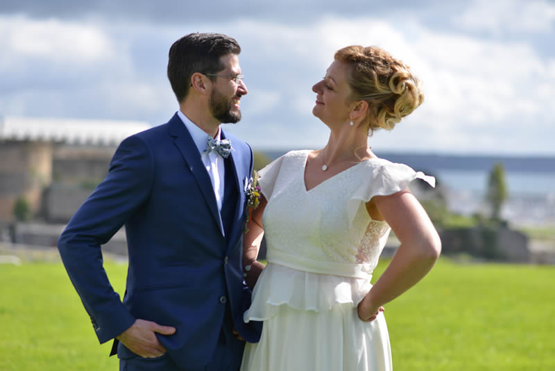Les mariés se regardent. La mariée posrte sa robe sur-mesure