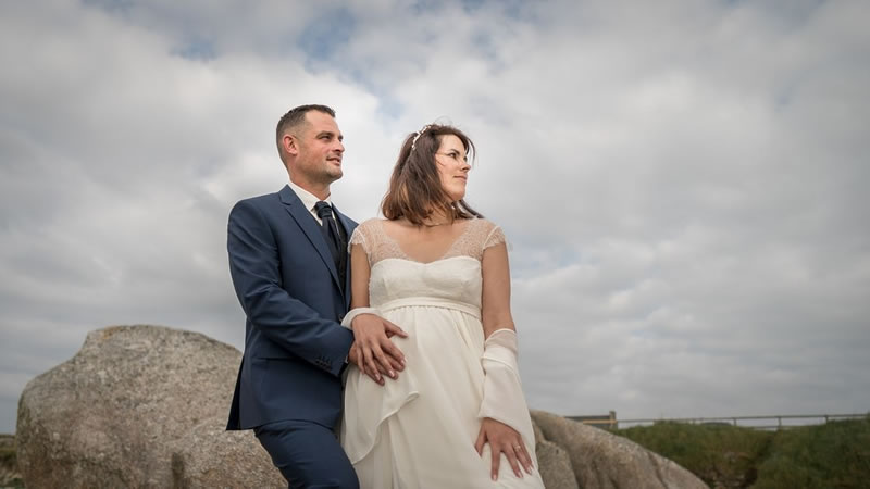 La mariée en robe avec son futur mati sur un rocher