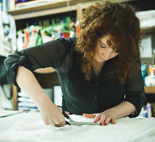 Maud Mitenne découpe robe de mariée sur-mesure dans l'atelier de Macfarlan