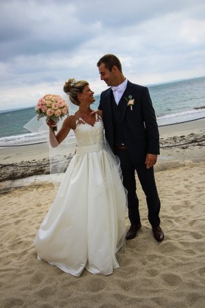 La mariée en robe et son futur mari sur la plage