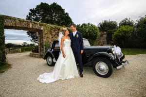 Les mariés devant une belle voiture ancienne