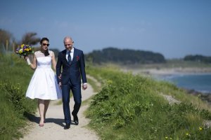 Mariée en Robe marchant sur la cote avec son futur mari